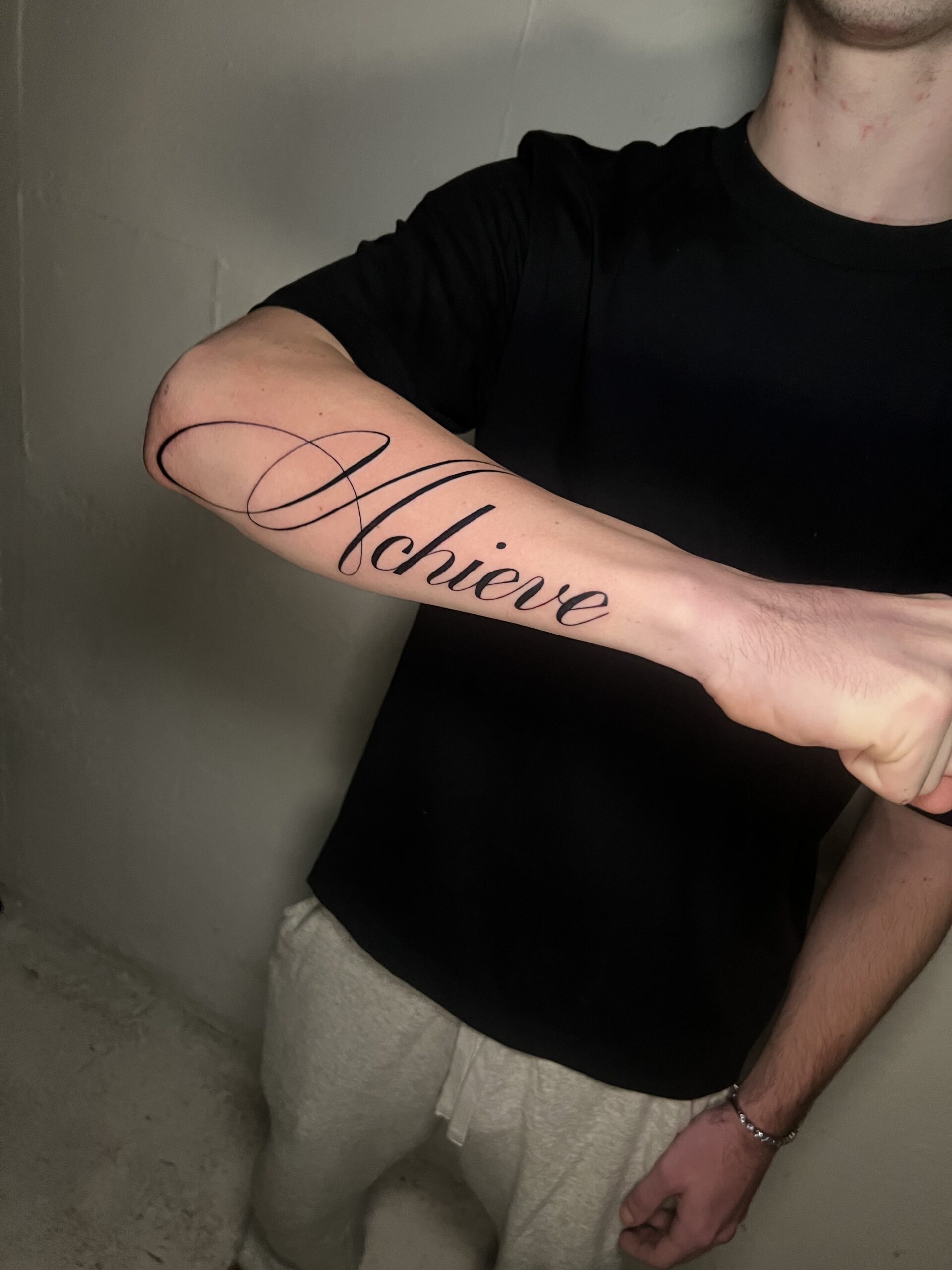 Clean black script tattoo with smooth lettering and balanced spacing