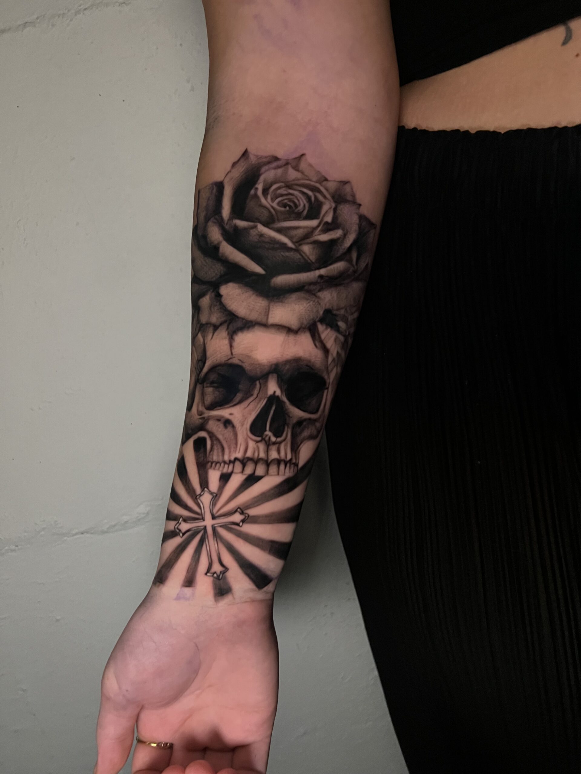 Black and grey realism skull and rose tattoo with high contrast shading