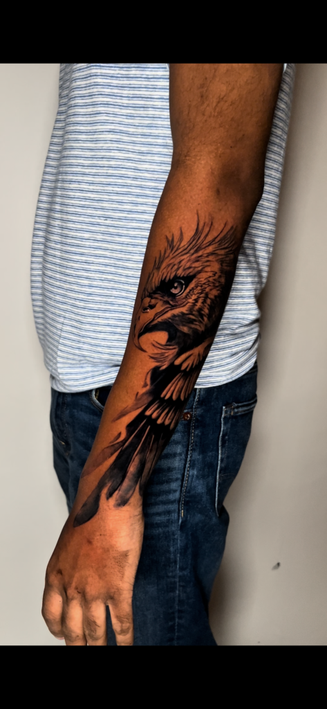 Black and grey realism eagle tattoo with detailed feathers and sharp expression
